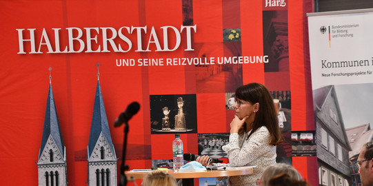Frau steht am Rednerpult.